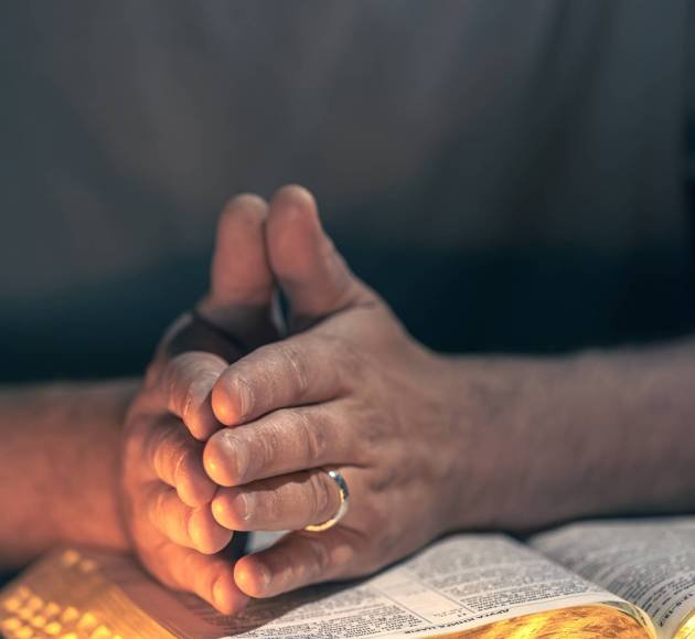 A man reads the Bible. Male hands with Bible close-up. A man reads the Bible. Male hands with Bible close-up. High quality photo. Religion concept. Space for text. Male hands on the Bible.